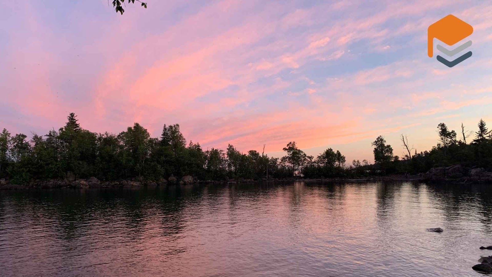 Pink sunset over calm lake and trees in zebulon, NC.