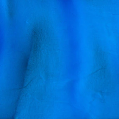 Textured vibrant blue fabric surface close-up.