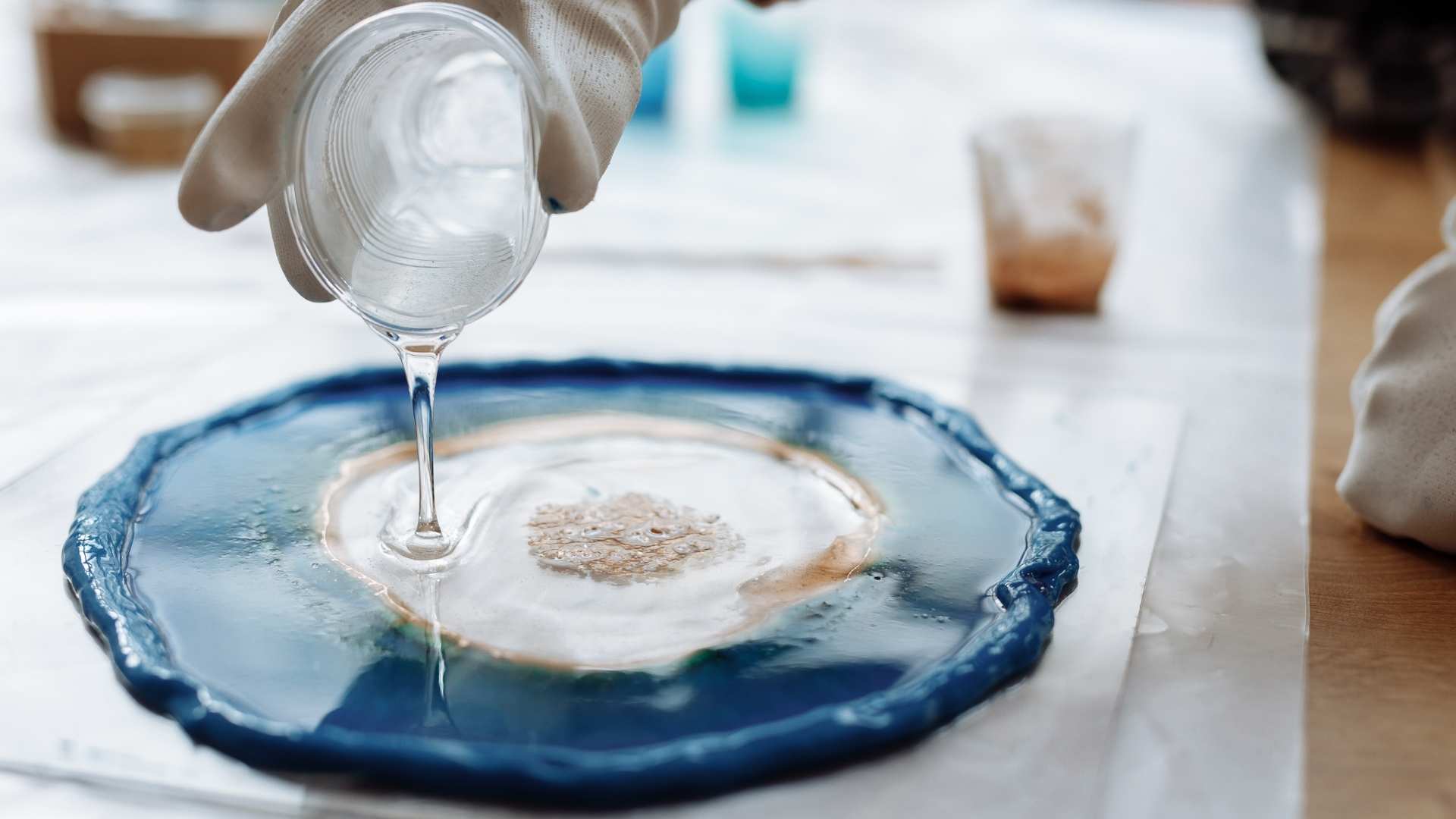 Pouring resin on blue artwork surface