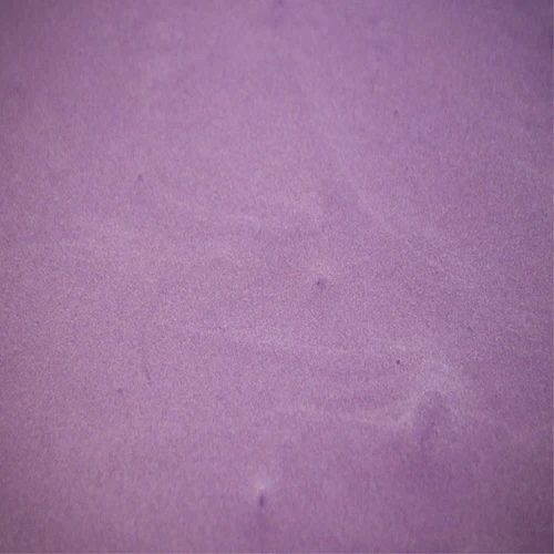 Close-up of textured purple sand surface.